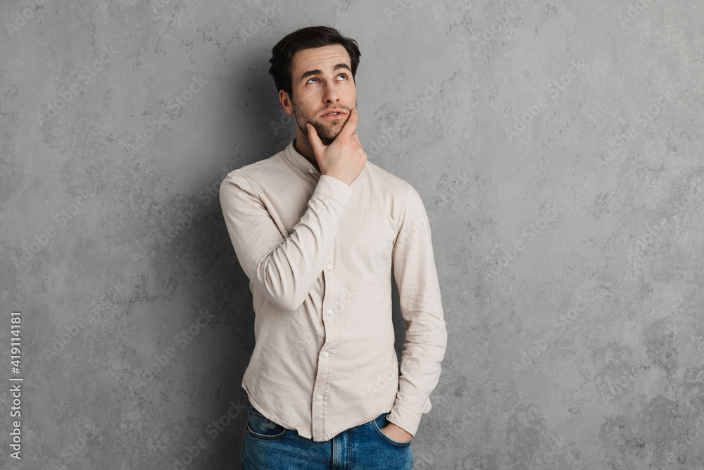 Pensive casual young man standing isolated Pensive casual young man standing isolated