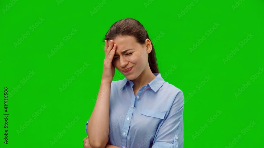 Tired girl suffering from painful headache and stress. Young girl in blue shirt holding hand on forehead on green background. Medical concept. Alpha channel Tired girl suffering from painful headache and stress. Young girl in blue shirt holding hand on forehead on green background. Medical concept. Alpha channel
