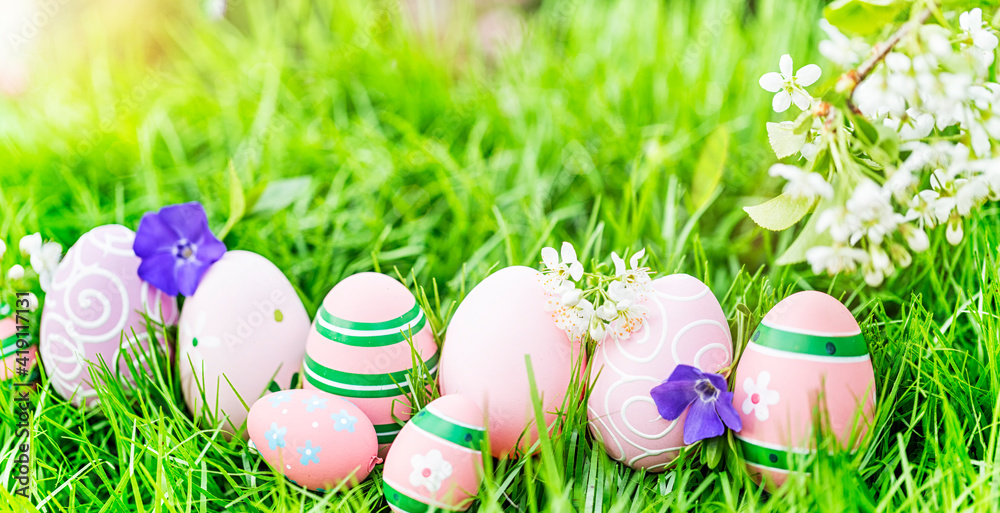 Fototapeta premium Card, background, wallpaper,postcard, greeting card with painted and decorated Easter eggs and eggs on the meadow in the spring natural landscape.
