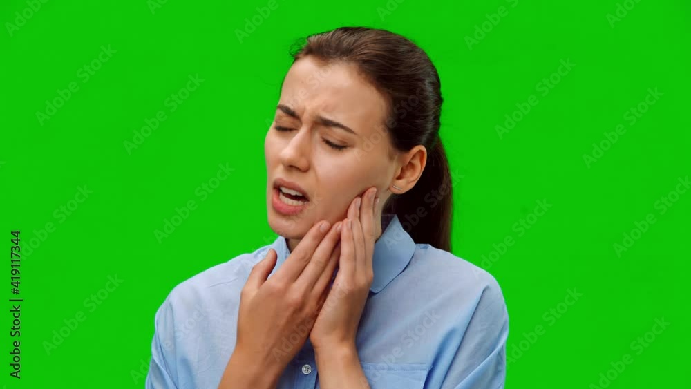 Woman suffering from annoying strong teeth pain. American woman in blue shirt on green background. Medical concept. Alpha channel Woman suffering from annoying strong teeth pain. American woman in blue shirt on green background. Medical concept. Alpha channel