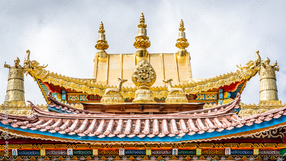 Fototapeta premium Golden roof details with Dharma wheel of Baiji or one hundred chicken Tibetan Buddhist temple Shangri-La Yunnan China