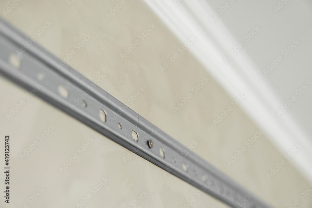 Close-up of stainless steel mounting rail for mounting kitchen cabinets on a wall. Close-up of stainless steel mounting rail for mounting kitchen cabinets on a wall.