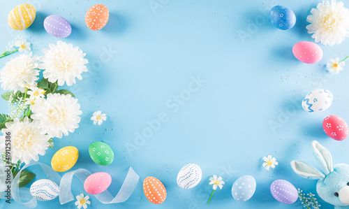 Happy easter! Colourful of Easter eggs with flower on pastel blue background. Greetings and presents for Easter Day celebrate time. Flat lay ,top view.