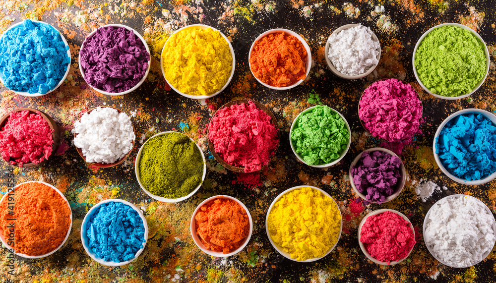 Happy Holi decoration, the indian festival.Top view of colorful holi powder on dark background. Happy Holi decoration, the indian festival.Top view of colorful holi powder on dark background.