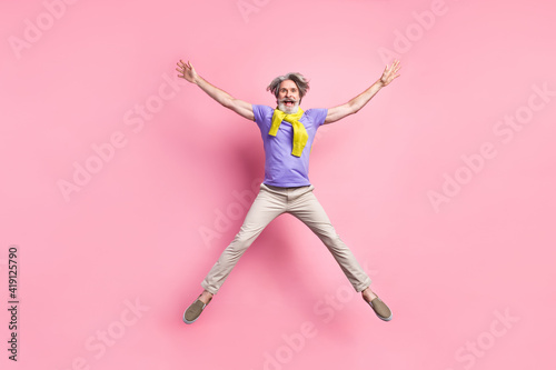 Full length photo of aged man jump up have fun excited star tied sweater isolated over pastel color background