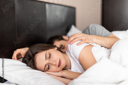Young couple sleeping on bed at home