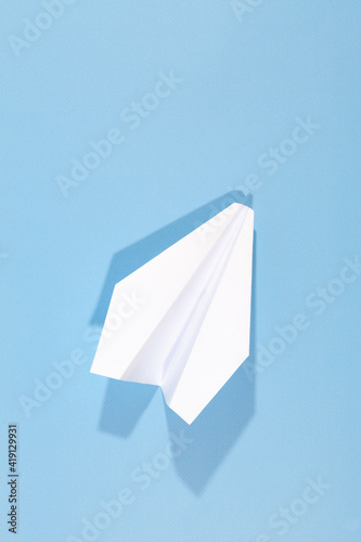 White paper airplane with shadow. Airplane on a blue background