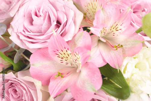 Close up of pink bouquet flower on white background with copy space. Floral arrangement with roses and alstroemeria.