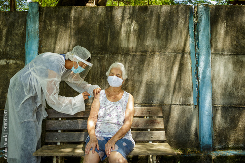 Idosa recebe vacina contra Covid em área rural de Guarani, estado de Minas Gerais, Brasil