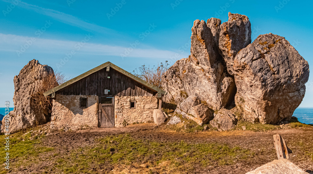 Beautiful alpine autumn or indian summer view with a hut surrounded by huge rocks at the famous Kampenwand summit, Aschau, Chiemgau, Bavaria, Germany Beautiful alpine autumn or indian summer view with a hut surrounded by huge rocks at the famous Kampenwand summit, Aschau, Chiemgau, Bavaria, Germany