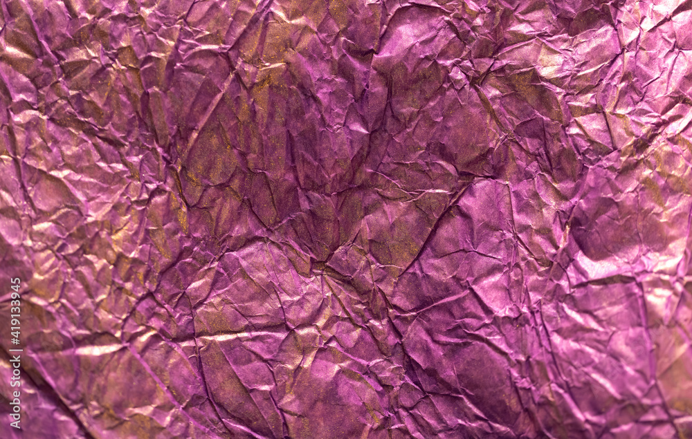 Obraz premium background is crumpled colored paper with metallic surface staining. Purple and gold
