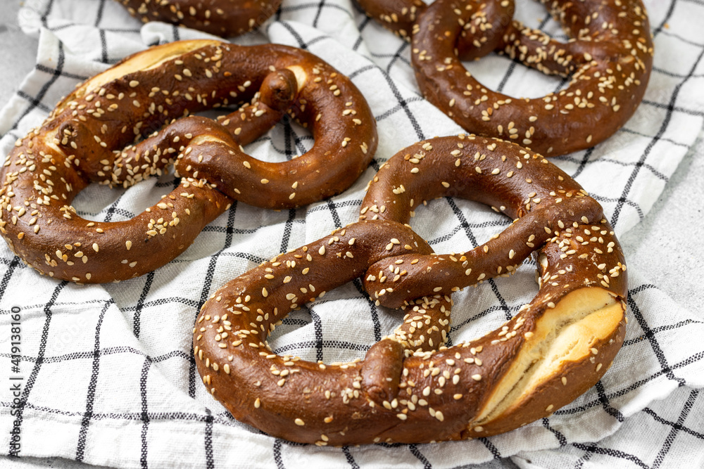 German pretzel. Pretzels with sesame seeds on the light gray kitchen table. Brezel on the table German pretzel. Pretzels with sesame seeds on the light gray kitchen table. Brezel on the table