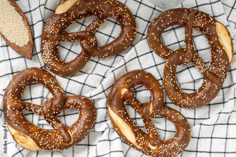 German pretzel. Pretzels with sesame seeds on the light gray kitchen table