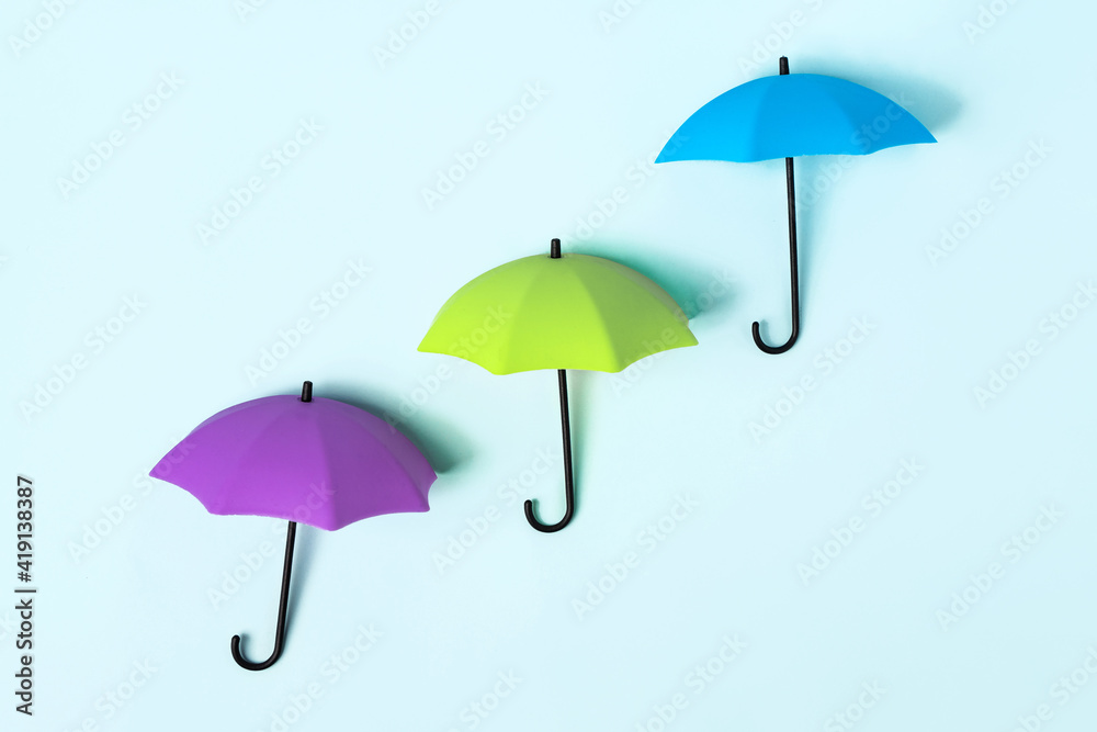 Colored umbrellas on a blue background. Conceptuality and place for the text