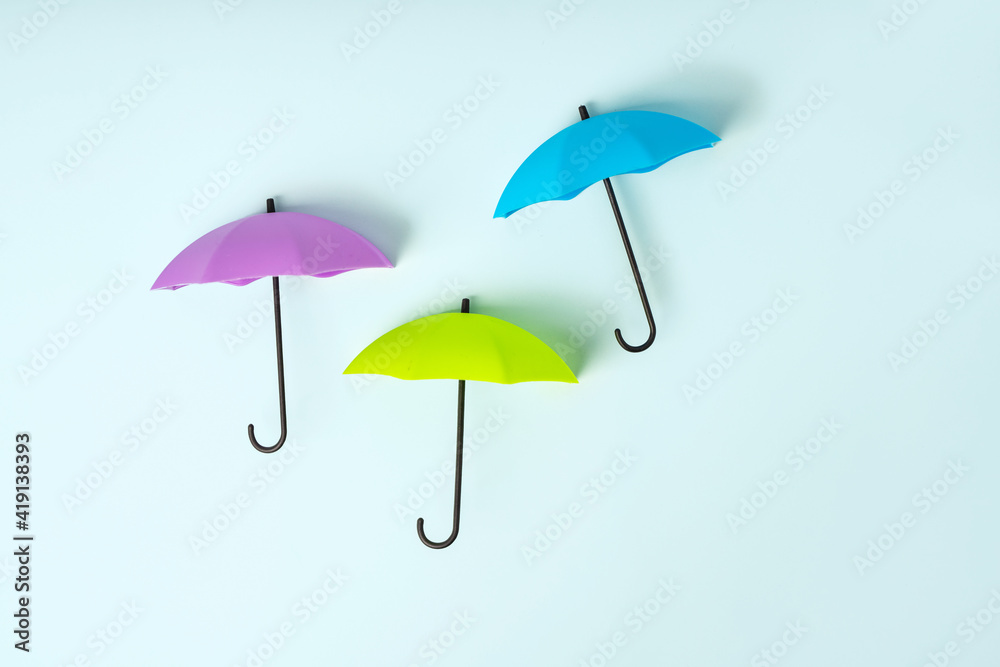 Colored umbrellas on a blue background. Conceptuality and place for the text