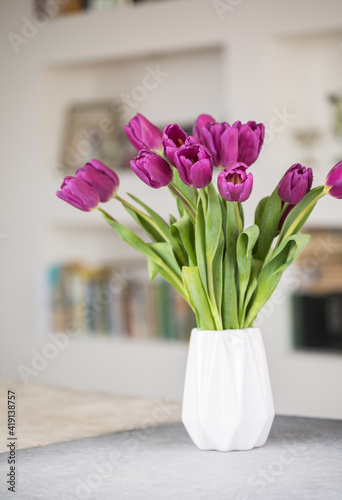 Spring background, spring tulip flowers in vase on the white wall background, easter spring border. Spring flower background, spring tulip flowers