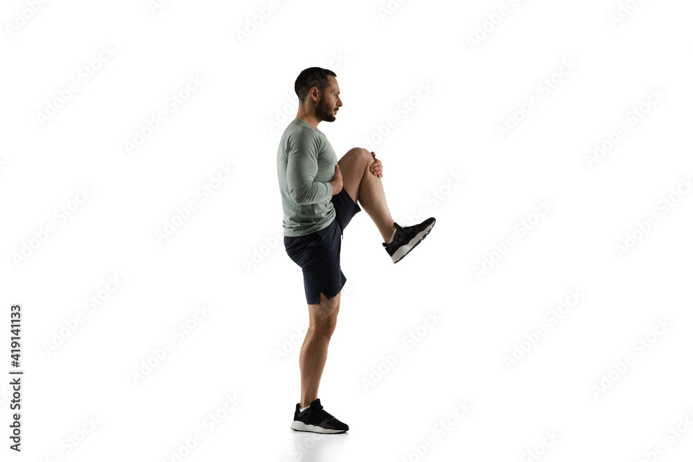 Stretching. Young caucasian male model in action, motion isolated on white background with copyspace. Concept of sport, movement, energy and dynamic, healthy lifestyle. Training, practicing. Authentic Stretching. Young caucasian male model in action, motion isolated on white background with copyspace. Concept of sport, movement, energy and dynamic, healthy lifestyle. Training, practicing. Authentic