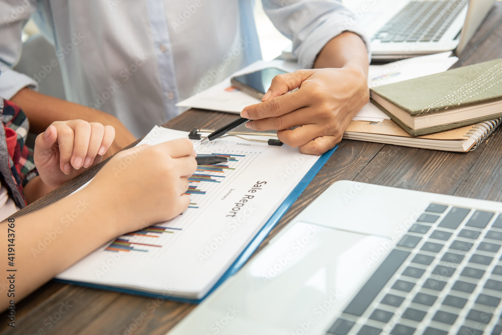 teamwork process. business people discussing the charts and graphs showing the results of their successful cooperation,  analyze financial report for business plan, selective focus.