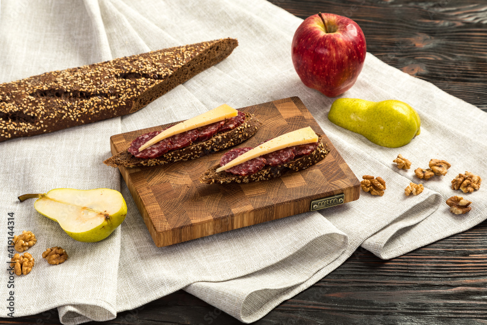Sausage and cheese sandwiches on a wooden cutting board