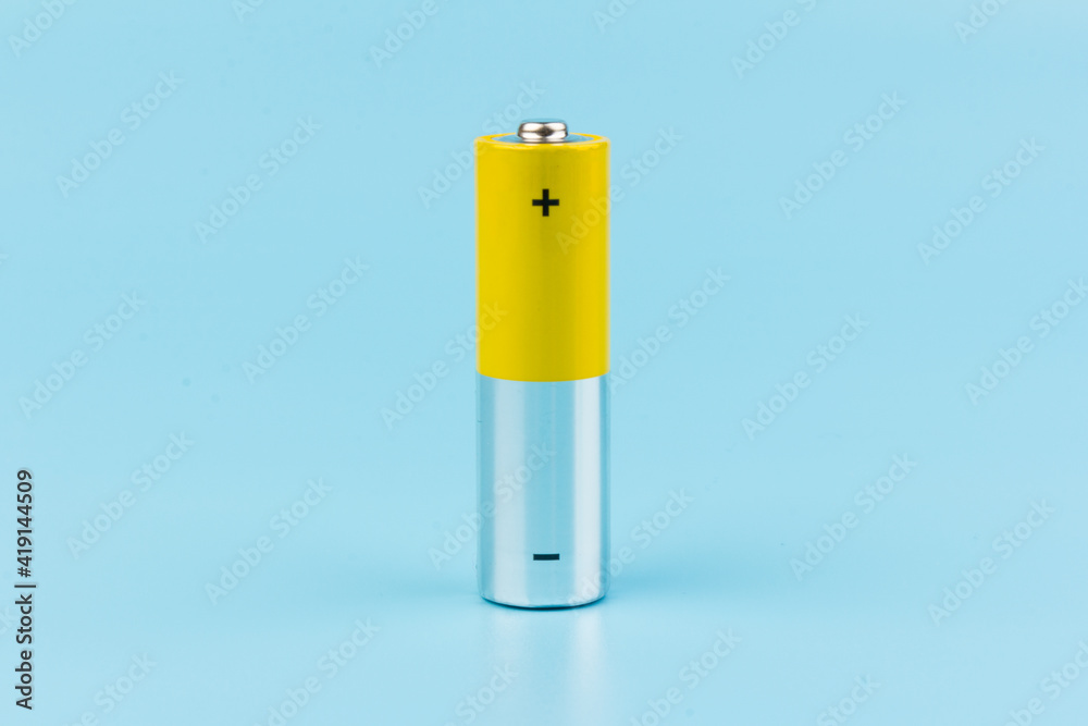Photo of gray-yellow alkaline AA batteries on blue background. Recycling of rechargeable NiMH batteries. The most popular size of accumulators. Copy space. Photo of gray-yellow alkaline AA batteries on blue background. Recycling of rechargeable NiMH batteries. The most popular size of accumulators. Copy space.