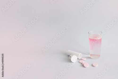 A glass of hot water and an antipyretic dissolving tablet in a glass.