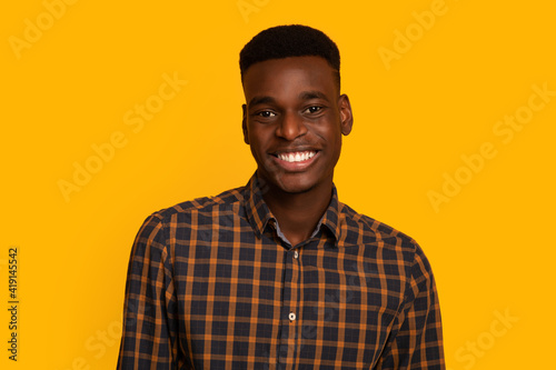 Portrait Of Positive African American Male In Checkered Shirt Smiling At Camera