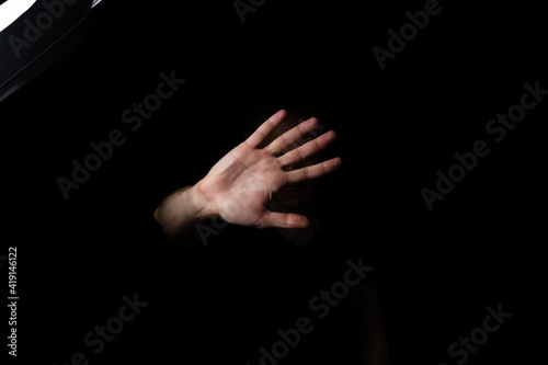 a man with a raised hand showing stop gesture on a black background