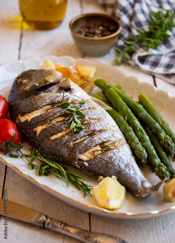 Roasted dorado fish with herbs and vegetables , healthy food