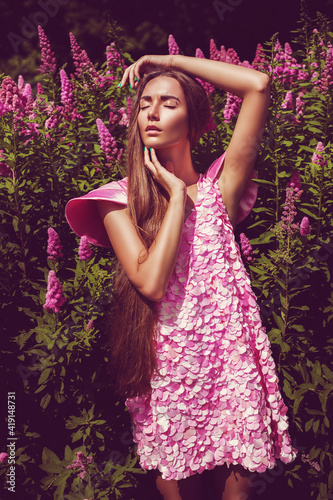 Sensual woman in pink petal dress at sunny day © Artem Popov