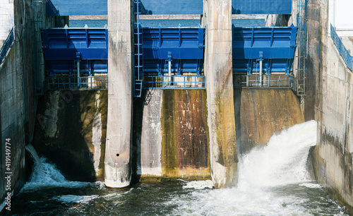 Massive power water flowing out of a lake dam. Green energy from water source. Hydroelectricity.