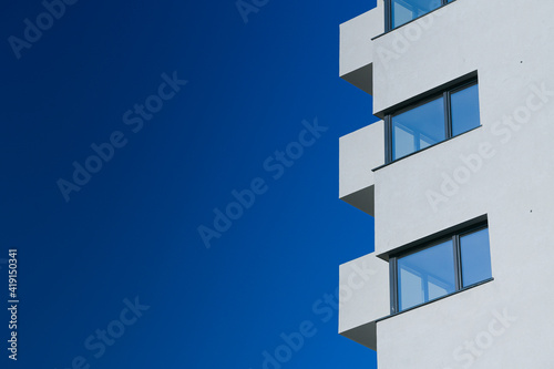 A new flat apartment building close up with clear blue sky in background