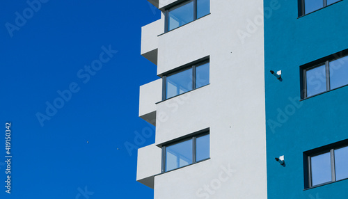 A new flat apartment building close up with clear blue sky in background