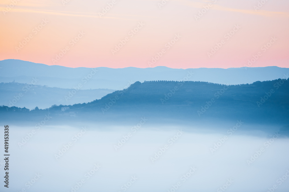 view of sunrise over the mountains mist and clouds under peaks