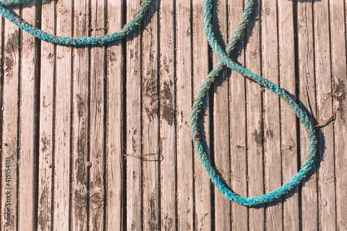 Old blue rope lies on a wooden deck