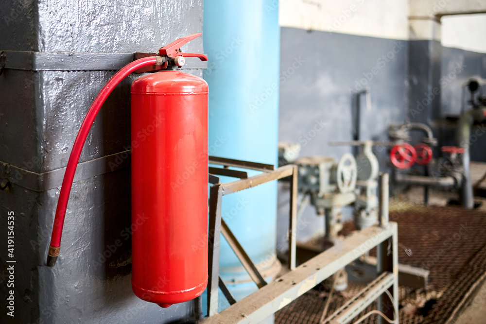 Fire extinguisher equipment in factory for fire protection system. carbon dioxide Fire extinguisher with pressure gauge on wall of production room. Concept of fire safety means of fighting fires.