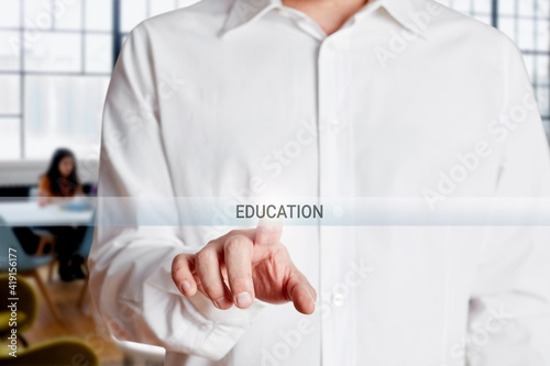 Male hand presses education button on a virtual screen.