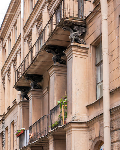 Vintage architecture classical facade building. Griffins support the balcony.