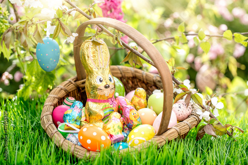 Easter card with chocolate Easter bunny sitting in nature on the Easter nest with Easter eggs.postcard, background.