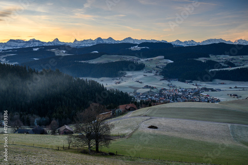 overlooking the village of Zäziwil at sunrise with hills of Emmental and Bernese Alps