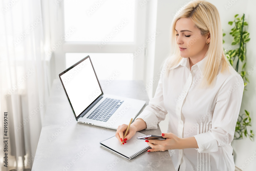 Portrait of a smiling young woman using laptop and smartphone Portrait of a smiling young woman using laptop and smartphone