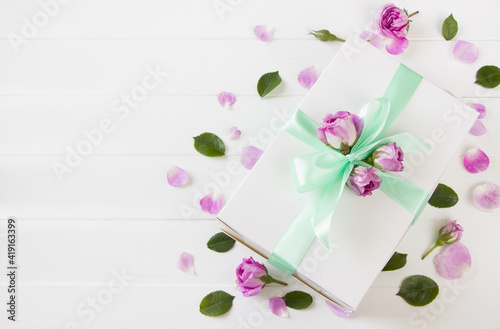 Gift box with pink roses on white wooden board. Template for Birthday, 8 march, Mother's day, Valentine's day, Wedding, women's day