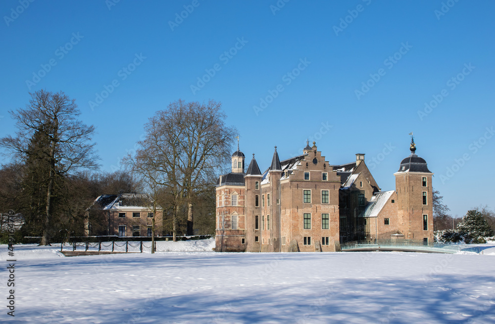 Winter scene with dutch historic architecture. Medieval castle and manor in snow landscape with moat and towers, rural nature. Culture travel destination in the netherlands. 