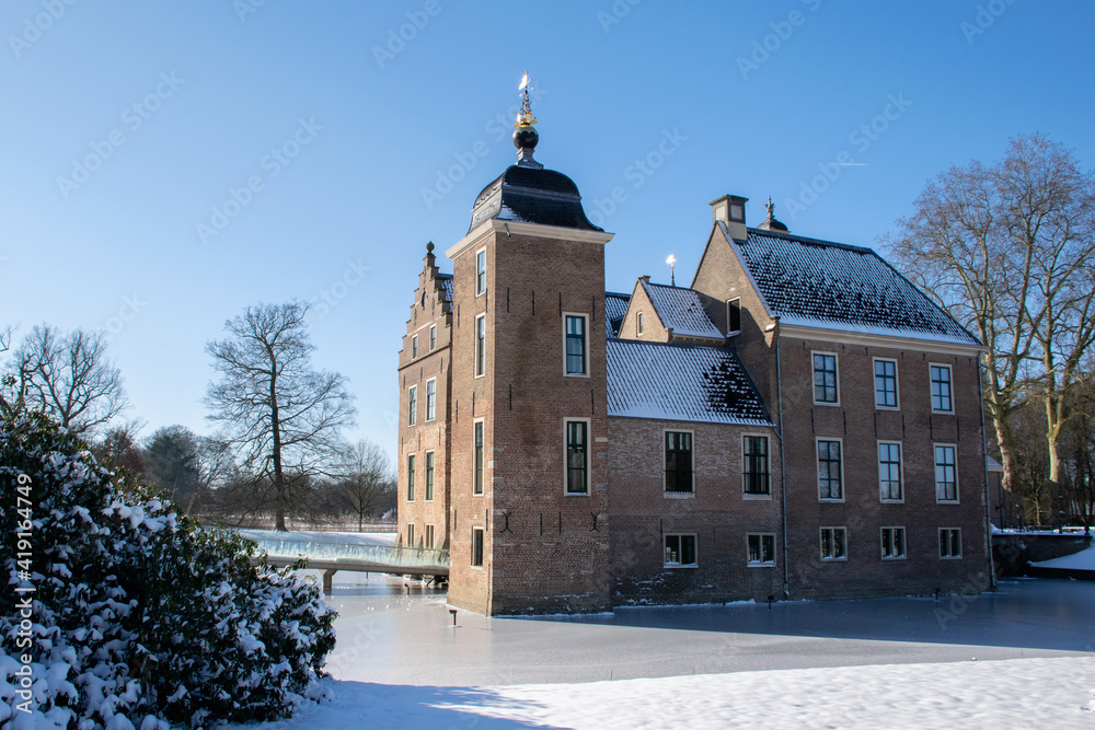 Winter scene with dutch historic architecture. Medieval castle in snow landscape with moat and towers, rural nature. Culture travel destination in the netherlands. 
