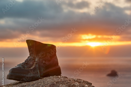 Finisterre Cape viewpoint at sunset with hiker boot mark photo