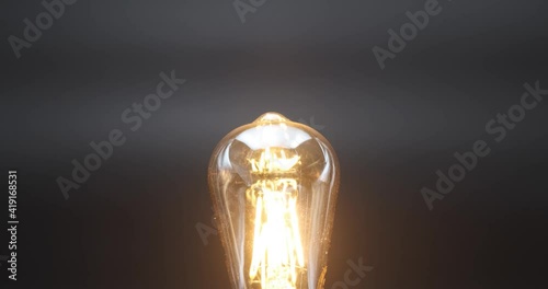 Close up shot of old retro vintage light bulb brighten light. Electric bulb shining, decoration for holiday.