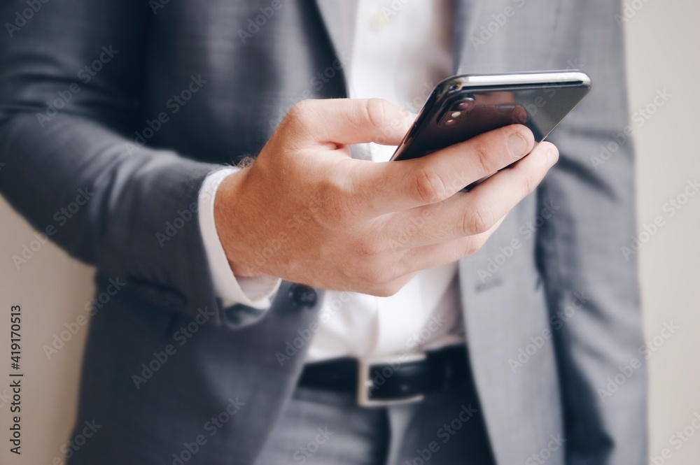 Midsection of a businessman using his mobile phone Midsection of a businessman using his mobile phone