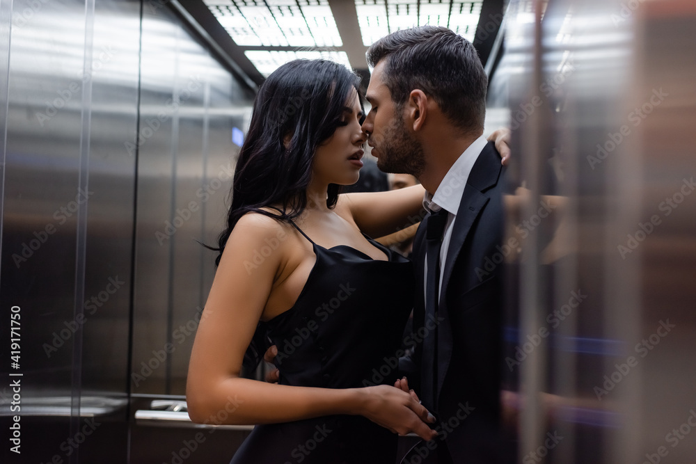 Sexy couple kissing in elevator on blurred foreground