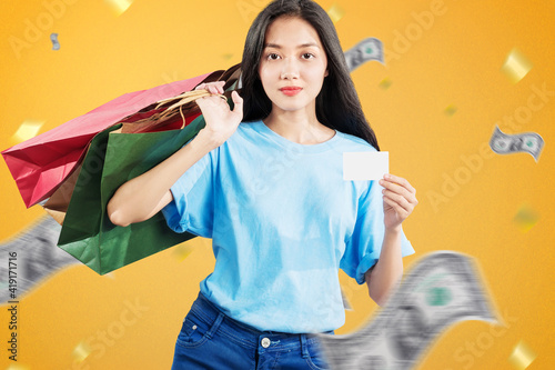 Asian woman carrying shopping bags holding empty cards standing