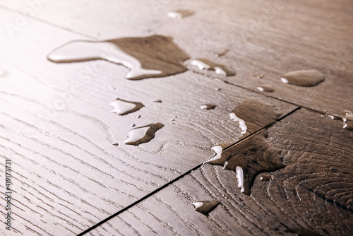 waterproof flooring - spilled water drops on wooden laminate floor