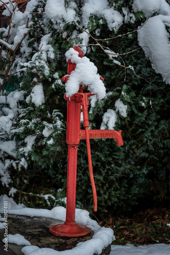 Red well in the garden covered with snow.
